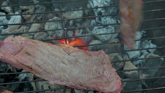Man cooking and rotating beaf steakes on grill. 4k video footage