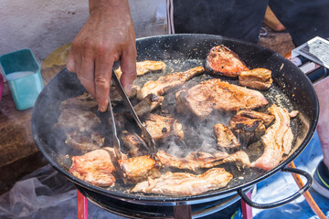 Hands of a man grilling meat on a barbecue. Grilled food