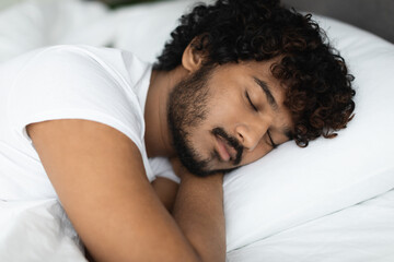 Closeup of indian guy sleeping alone in bed