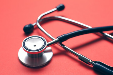 Medical stethoscope on red background. Medical care concept