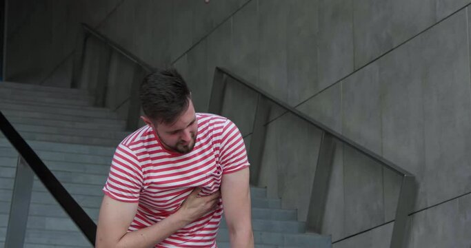 Man having heart attack on stairs, outdoors