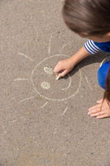 Children draw on the pavement with chalk. Selective focus.