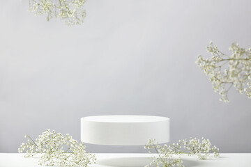Flying empty white podium and white flowers on grey background. Mock up stand for product...