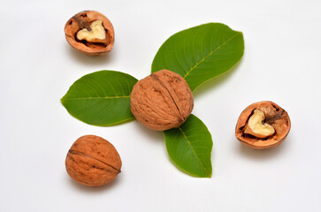 whole and chopped walnuts with leaves on a white background close-up