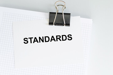 STANDARDS text on a card on a notepad on a clip on a light table