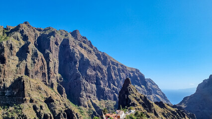 Sharp pinnacle in centre of remote tourist village Masca in the Teno mountain range, Tenerife, Canary islands, Spain, Europe. Rock formation is surrounded by steep cliffs. Gulch connceted to the sea