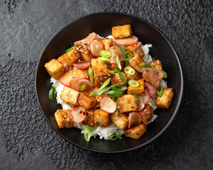 Fried tofu with radish, spring onion and garlic, ginger dressing in black bowl