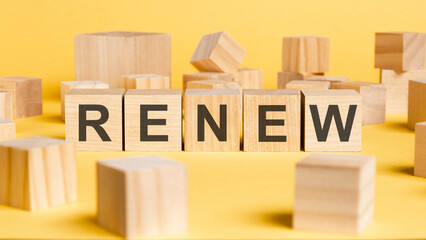 the word renew written on wooden cubes on yellow background