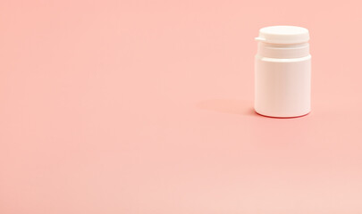 white plastic bottle on pink background. copy space 