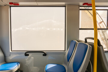 New comfortable seats in a modern public bus. A large window in the bus for emergency exit in case of an accident. Seats on the bus for the elderly and people with disabilities.