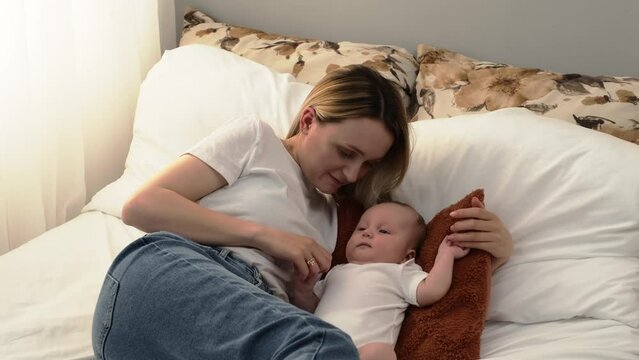 mother kisses the baby. the child lies on a pillow. mother love concept