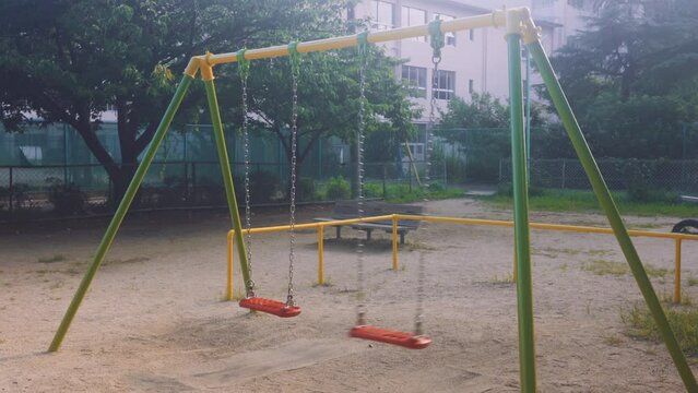 晴れた日の公園で、誰もいないブランコが揺れている、寂しそうです。