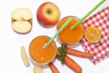 Natural organic fresh juice made of carrots and apples on white background. Healthy carrot, apple and lemon smoothie.