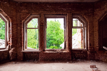 Abandoned old red brick building windows without glasses, view from inside to green trees
