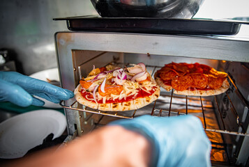 hand of chef baker making mini pita pizza at kitchen. The process of making pita pizza. cooking italian pizza