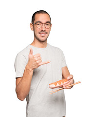 Young man using chopsticks to eat sushi