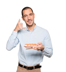 Young man using chopsticks to eat sushi