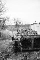 A burnt-out Russian tank in a liberated Ukrainian village. Russia's attack on Ukraine. Special operation. Russian aggression in Ukraine. Genocide of the Ukrainian people. Black and white photo