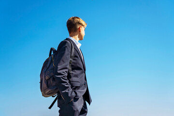 Handsome teenager 15-18 years old high school student with a school bag on the way to college. Copyspace.