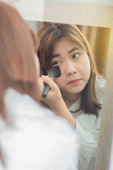 Asian beautiful woman making make-up with mirror at the desk