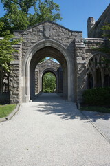 Fototapeta na wymiar Stone Archways Openign to Green Trees in Sunlght on Summer Day