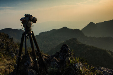 Dslr digital professional camera stand on tripod photographing mountain, sunset and cloud landscape. nature background.image,picture on screen. dslr camera shoting nature landscape.camera on a tripod