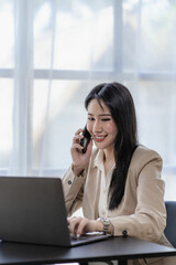 Businesswoman in a suit holding a smartphone with financial reports in the office vertical picture