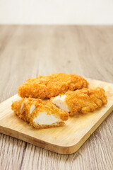 Sliced fried chicken on wooden butcher table