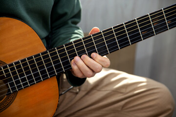 Fototapeta na wymiar Plays the guitar. Guitar strings and fingers. Musical instrument. Man and guitar.