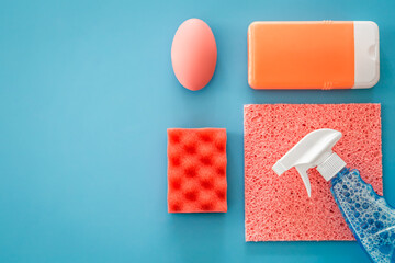 House cleaning products on blue background, flat lay.