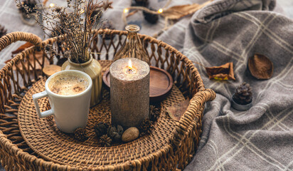 Fototapeta na wymiar Cozy home composition with a cup of coffee, a candle and decorative details.