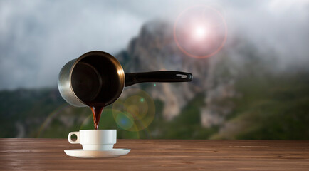coffee maker with cup of coffee on mountain background