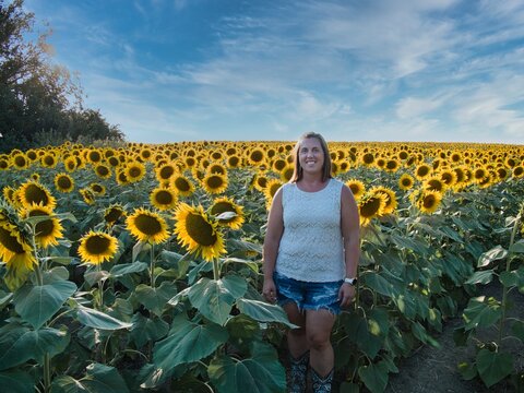 Woman Standing in Large Sunflower Field in Kansas