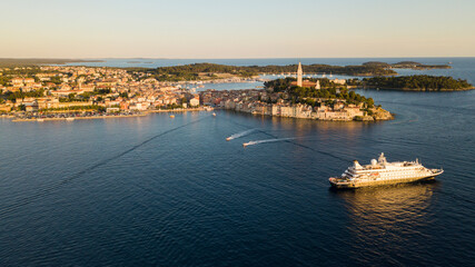 Fototapeta premium Beautiful Rovinj town (popular tourist resort and an active fishing port) at sunset. Aerial photo. The old town of Rovinj, Istria, Croatia.