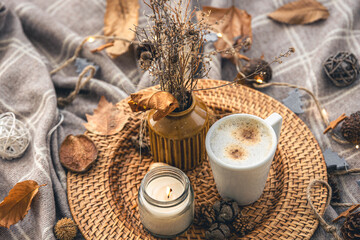 Cozy home composition with a cup of coffee, a candle and decorative details.