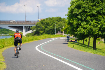 Obraz premium 初夏の緑と青い空、手賀大橋に向かって自転車競技の練習（手賀沼）