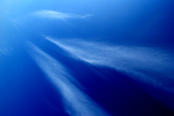 Abstract look of natural cirrus clouds on blue sky. Long clouds making unusual view.