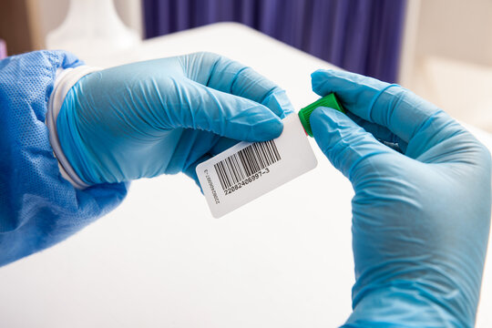 Closeup of a nurse labelling a test tube with blood sample in a clinical laboratory