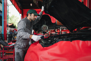 Obraz premium Automobile mechanic man checking car damage broken part condition. diagnostic and repairing vehicle at garage automotive, Concepts of car care check and fixed and services insurance.