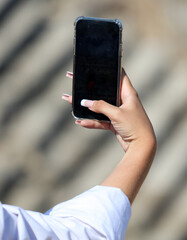 The phone is in the girl's hand.