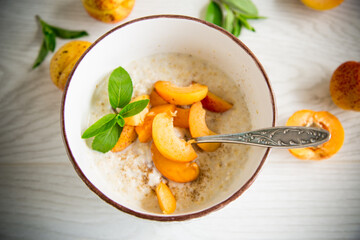 Healthy breakfast of apricot oatmeal with fresh fruit