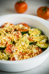 raw zucchini and tomatoes sliced with cheese, prepared for baking