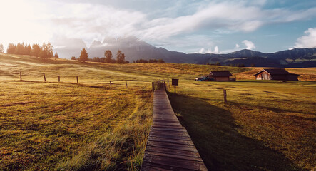 Obraz premium Stunning nature landscape in Dolomites Alps. Summer Mountain meadow Alpe di Siusi or Seiser Alm with tipical wood huton highland. seiser alm Is one most famous natural landmark and travel destination