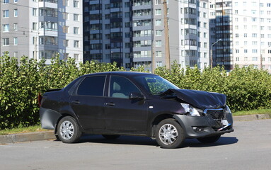 A black wrecked car after an accident is parked on the street, Kollontai Street, St. Petersburg, Russia, September 2022