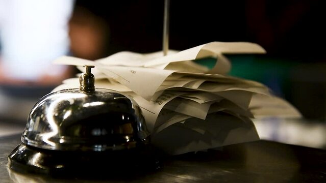 Checks from completed orders in the bar or restaurant kitchen impaled on a sharp thin iron needle on a stand.