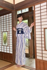 古民家の和室でポーズをとる浴衣を着た微笑む若い女性