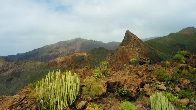Mountain aerial flight above edge of steep cliff, mountain ranges on sunny day. Summer adventure journey in nature outdoors. Travel exploring Tenerife Canary Island. 4k drone scenery, landscape.
