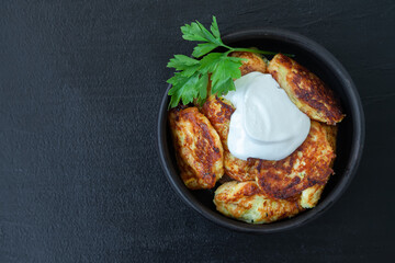 Zucchini pancakes with greens and sour cream