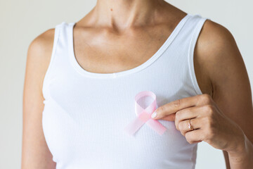 Woman with pink ribbon symbol of breast cancer awareness month.