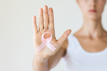 Woman with pink ribbon symbol of breast cancer awareness month.